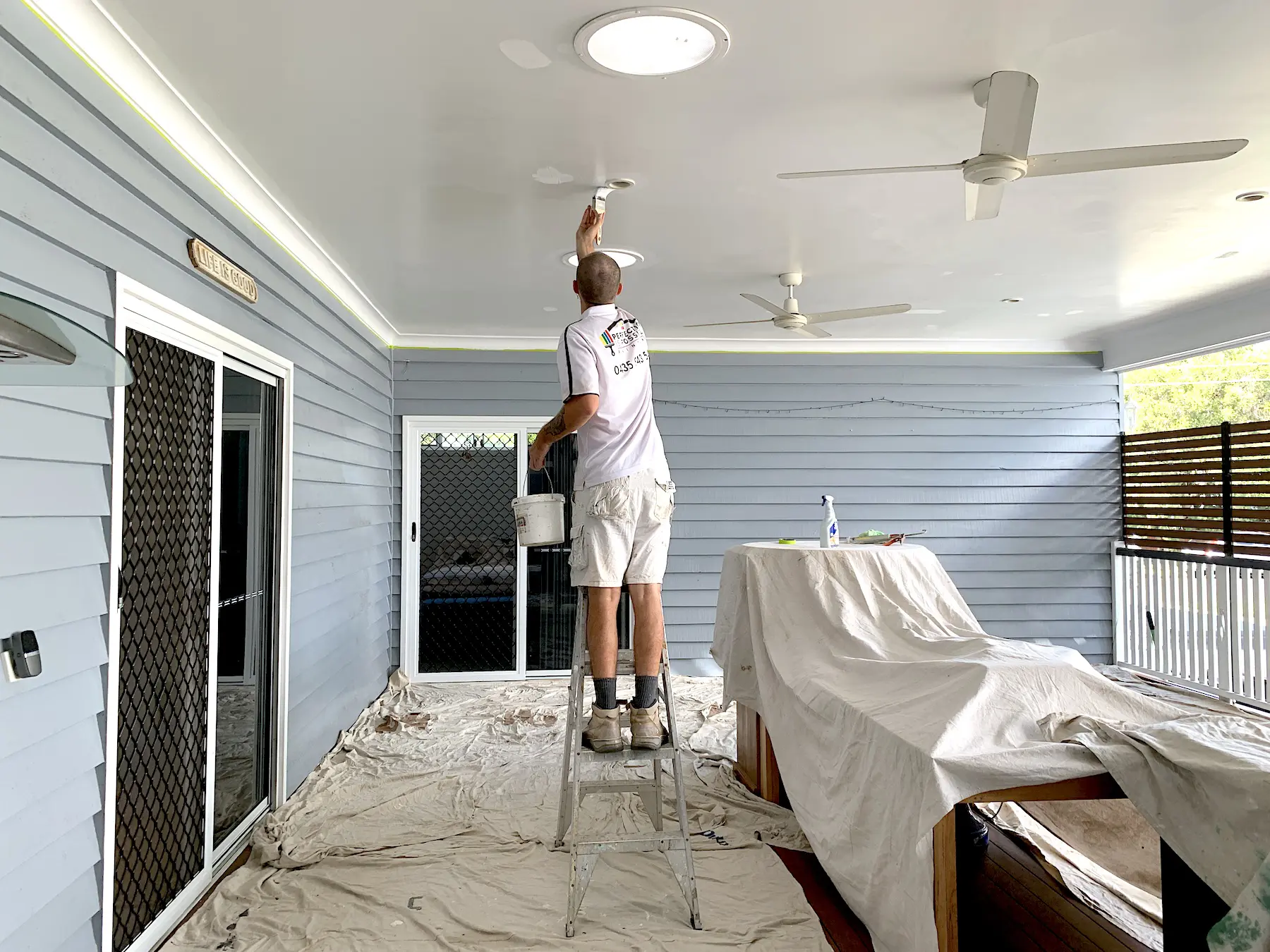 painting carefully on ceiling around light fitting